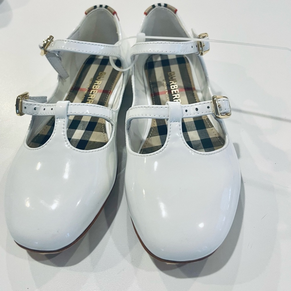 This double-strap mary-jane flat in optic-white leather. Adjustable straps